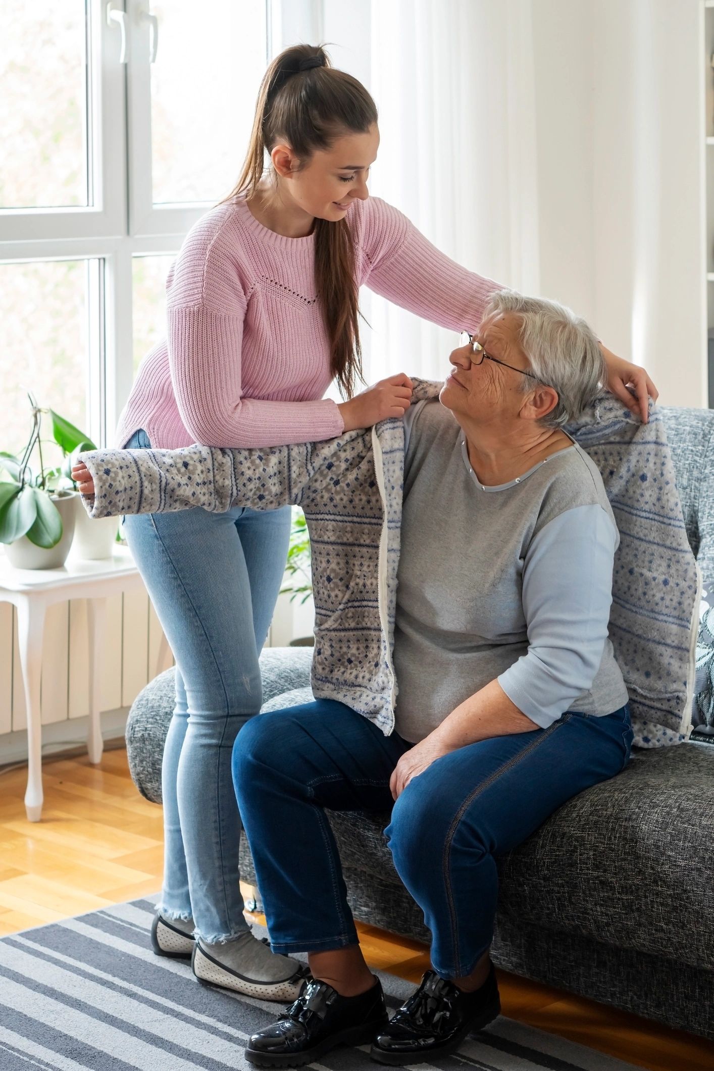 Granddaughter helping her grandmother at home