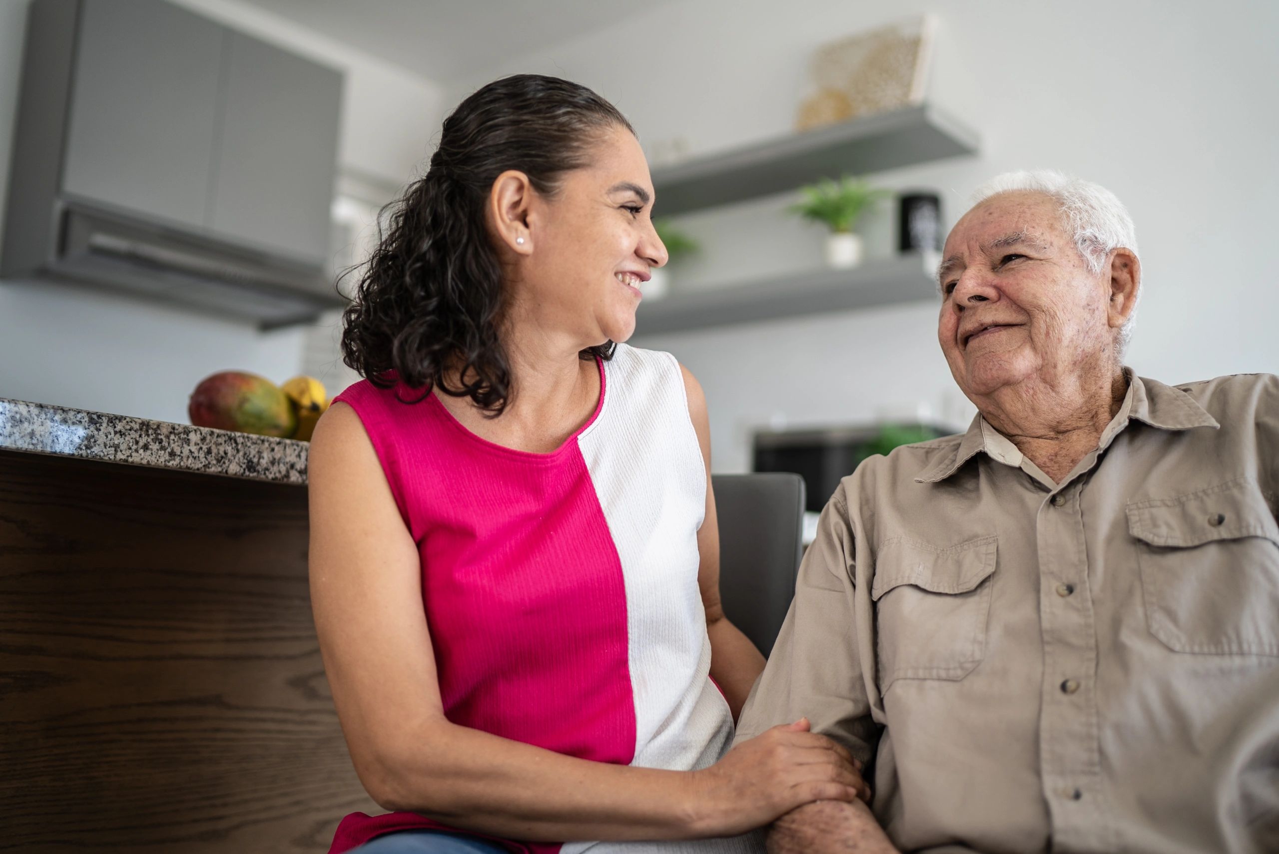 Senior and caregiver talking at home