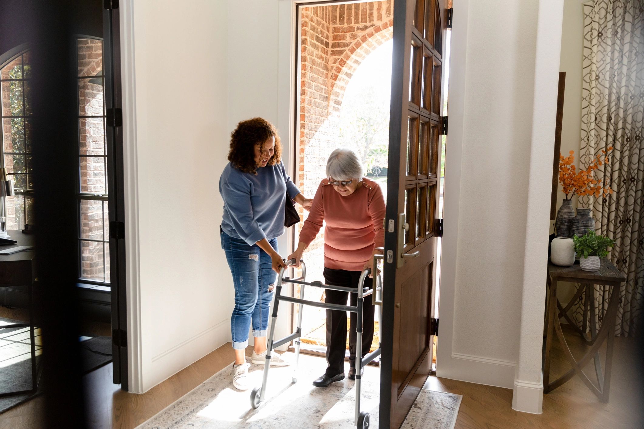 Caregiver helping a senior enter her home